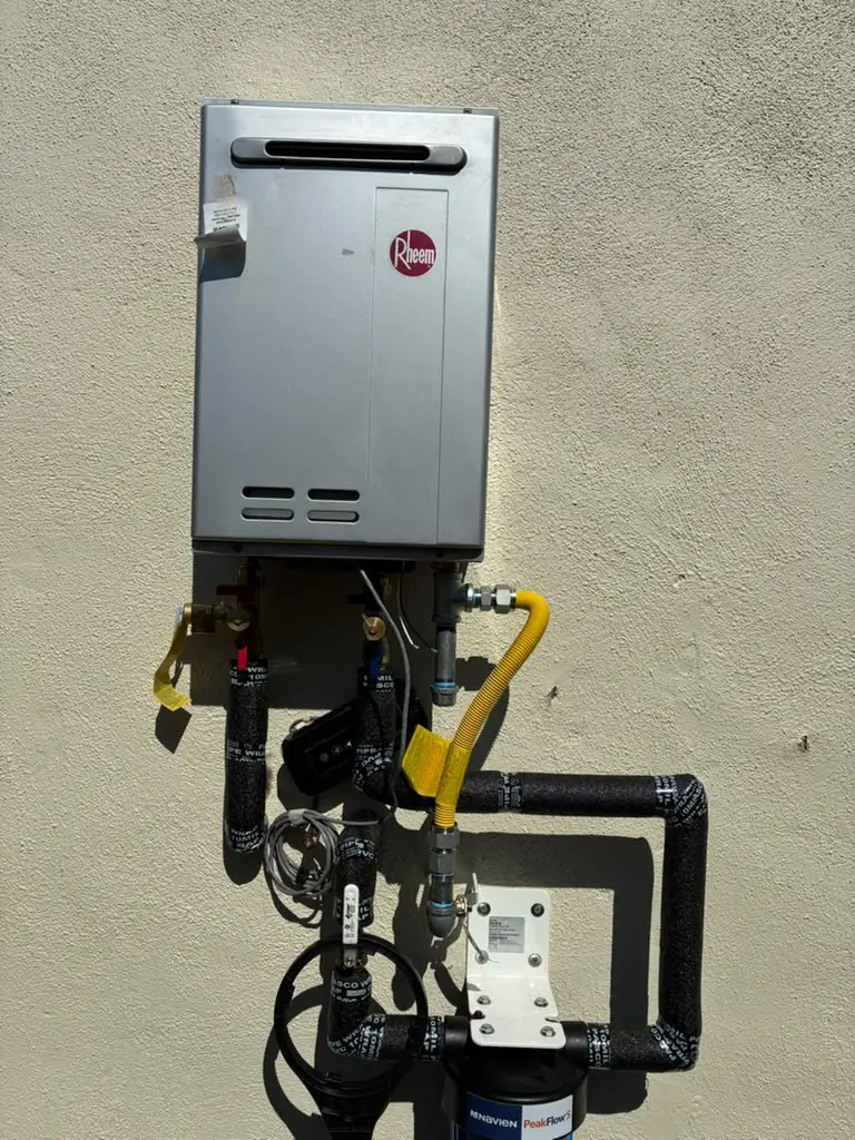 The team at RS Plumbing installed a premium Rheem tankless water heater equipped with a Navien PeakFlow S filtration unit